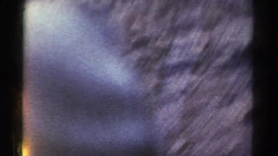 Final 1967 Colorado 8mm frame dominated by blur, blue-purple color shift, light leak, and physical film edge artifacts.