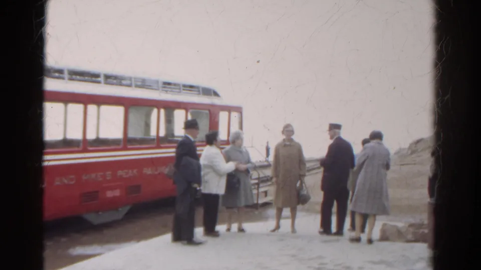 1967 Colorado frame of passengers and a uniformed attendant beside the Manitou and Pike's Peak Railway car.