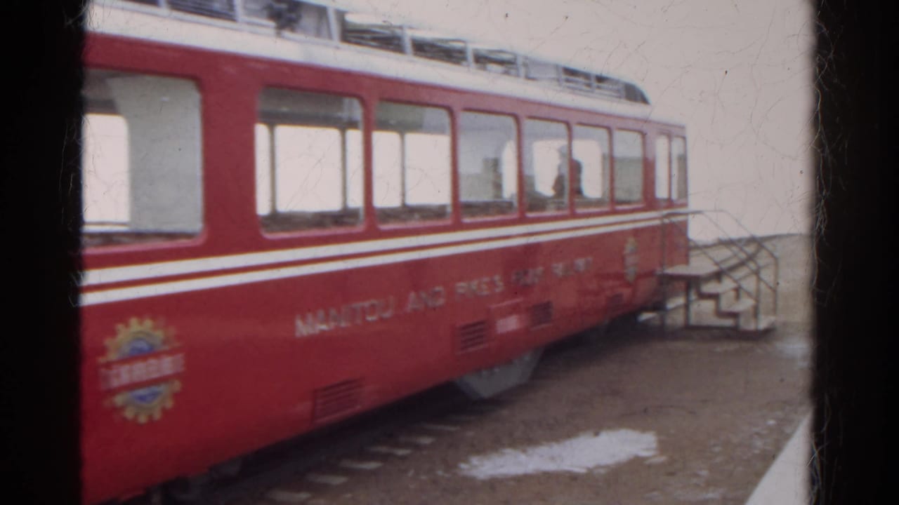 A red and white Manitou and Pike's Peak Railway car is seen close-up at a Colorado mountain station in 1967 footage.