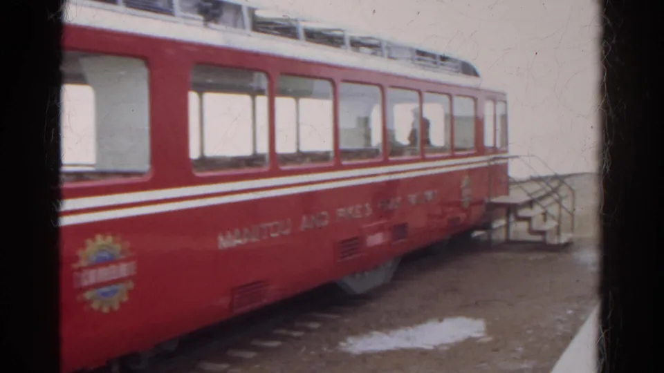 A red and white Manitou and Pike's Peak Railway car is seen close-up at a Colorado mountain station in 1967 footage.
