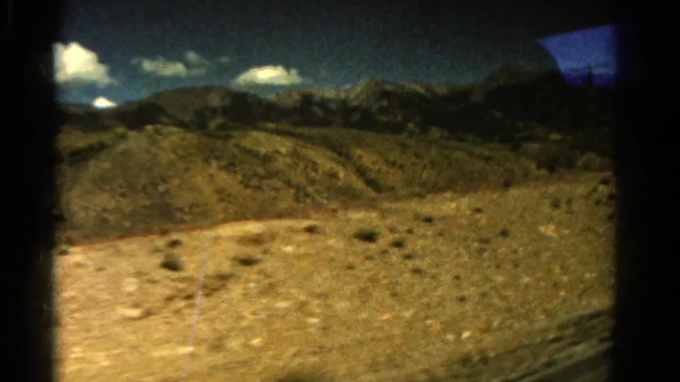 The closing frame shows 1967 Colorado mountain terrain through a car window, with rocky ground, scrub, clouds, and distant ridges.