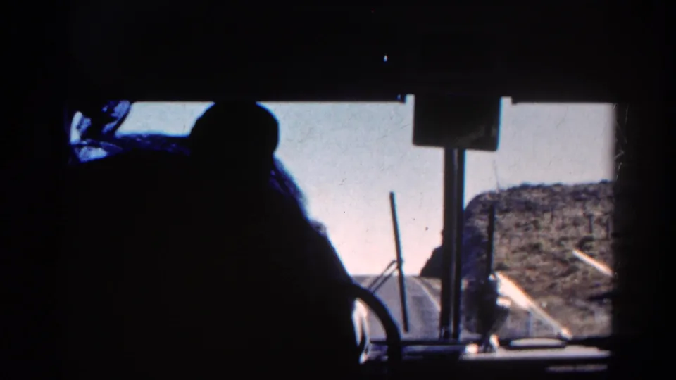 Final 1967 Colorado 8mm frame shows the cab silhouette shifting near the windshield as rocky terrain and bright sky pass outside.