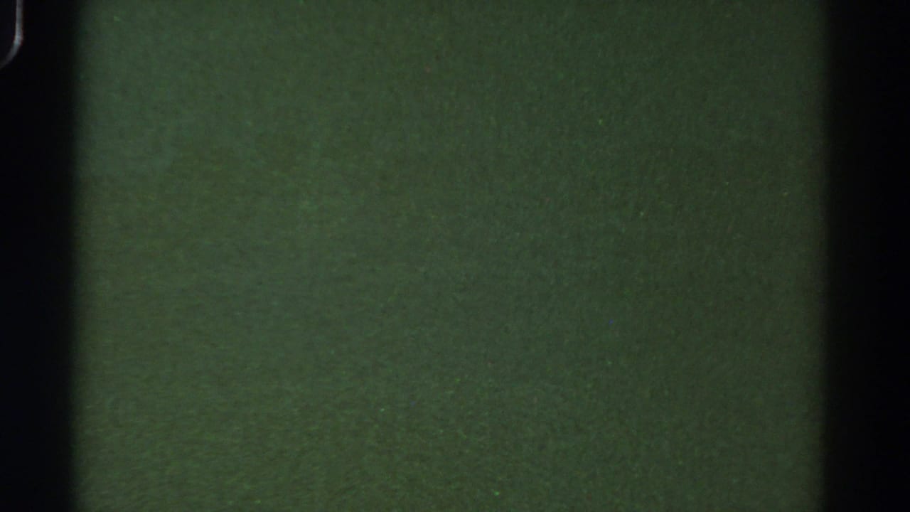 Murky green underwater frame with dark film borders and faint grain.
