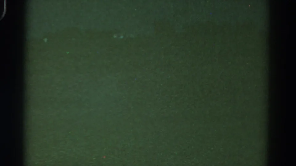 1967 Colorado 8mm frame showing murky underwater texture with pale specks and a dark film border.