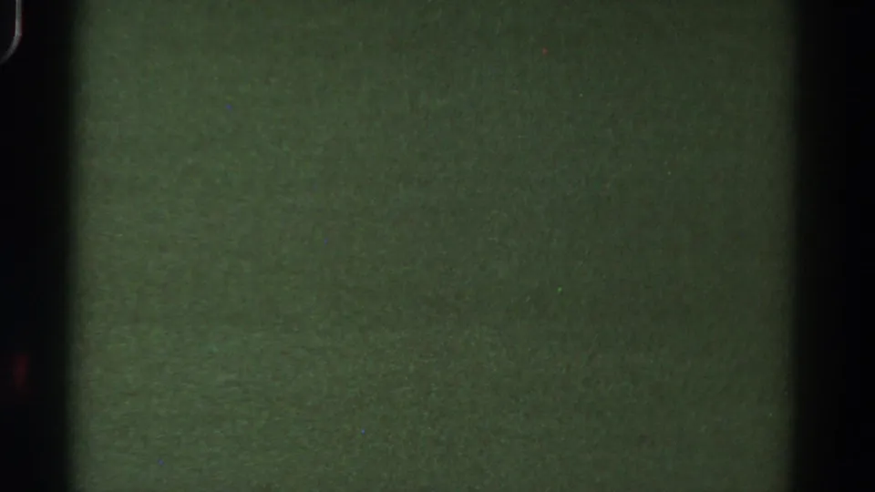 1967 Colorado 8mm frame with a central gate-like shadow, muted green exposure, grain, and small dust marks.