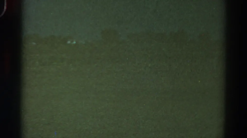1967 Colorado 8mm frame showing a horizontal seam-like band, vertical gate shadows, dust, and uneven green exposure.