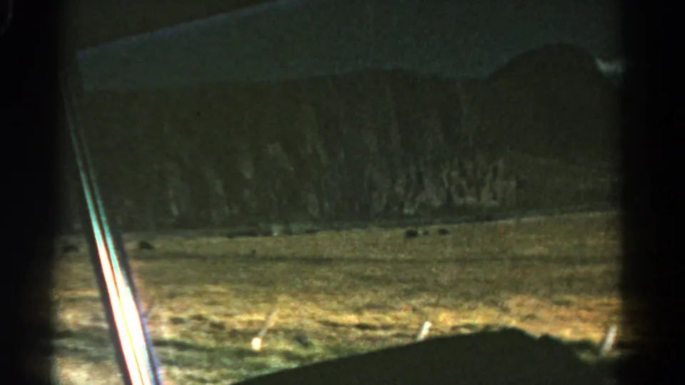 1967 Colorado home-movie view of grassy fields and mountain ridges from inside a moving vehicle.