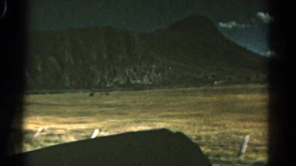Colorado landscape footage shows a grassy roadside field and a mountain slope through the vehicle window.
