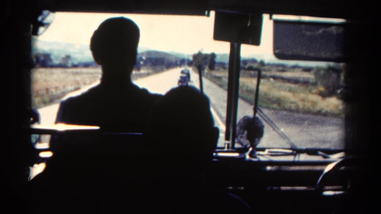 Front bus view with seated silhouettes and countryside visible through the windshield.
