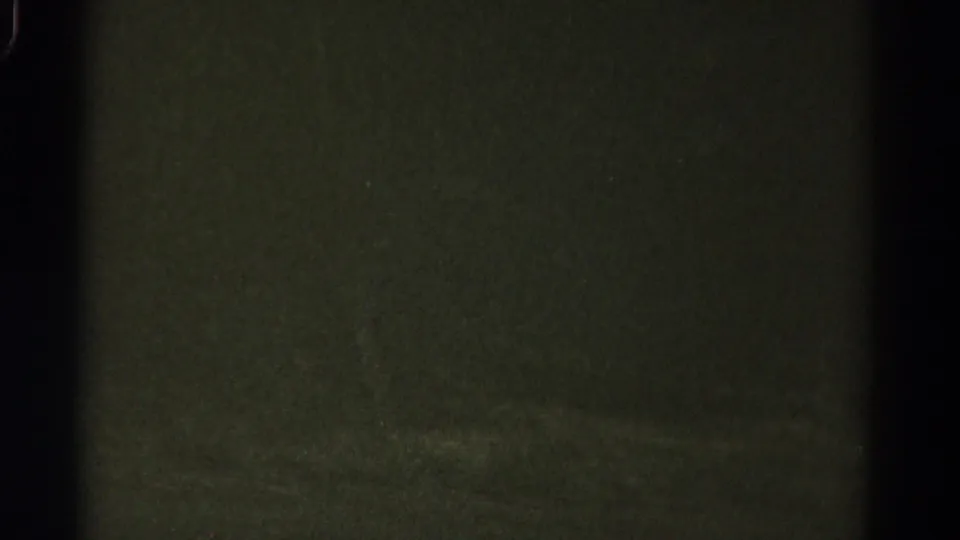 Low-light 1967 Colorado vehicle-view frame showing dark pavement and soft pale marks on the road surface.