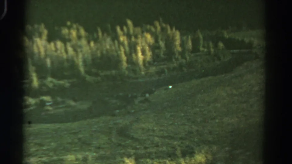A 1967 Colorado landscape frame shows a grassy slope, distant trees, and muted home-movie color with film grain.