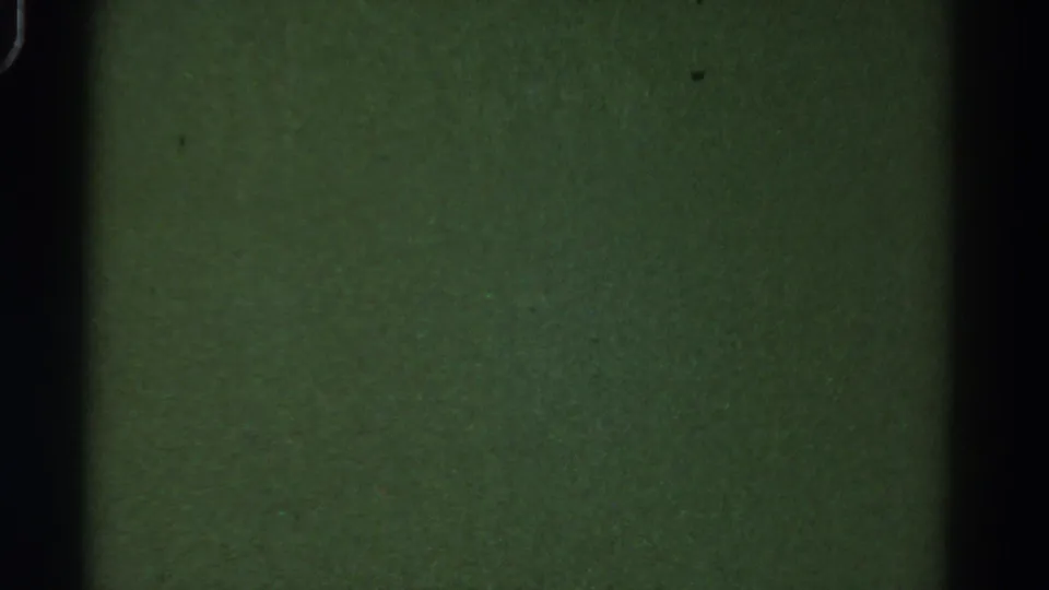 1967 Colorado 8mm frame with a flat green exposure, dark vertical film edge, specks, and soft analog texture.