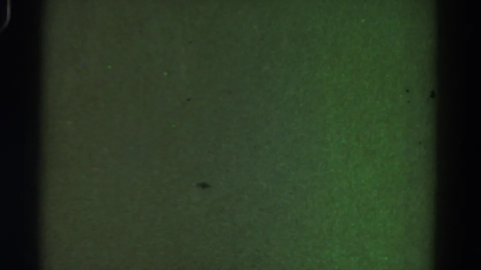 1967 Colorado 8mm frame showing a darker green blank field, black vertical borders, dust marks, and uneven exposure.