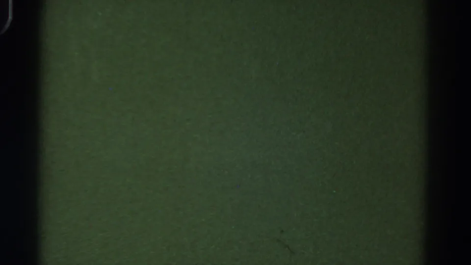 Green-toned blank 8mm frame from the 1967 Colorado reel, crossed by dark frame edges and faint film texture.