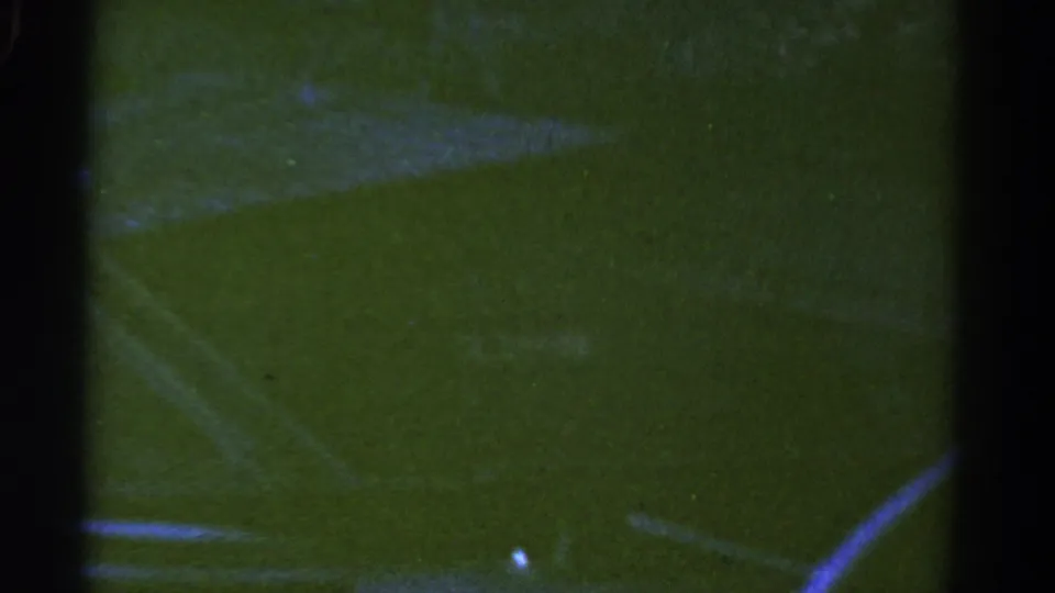 End frame of the 1967 Colorado 8mm clip with a partial truck or trailer edge beside a curved white line on the field.
