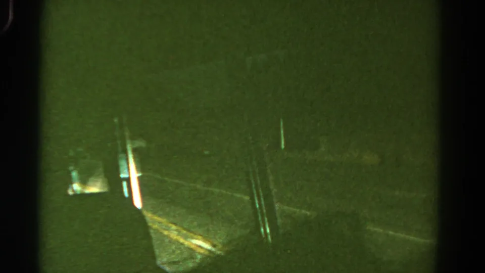1967 Colorado 8mm frame showing a dim night road from inside a moving vehicle, with green tint, blur, and black film borders.