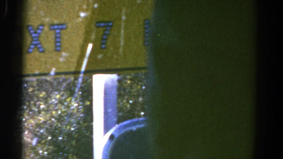 A yellow sign with partial lettering, including NEXT, appears in a blurred 1967 Colorado nighttime vehicle shot.