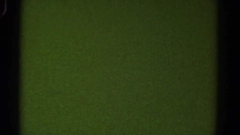 Green-tinted 8mm Colorado travel frame with dark vertical edges and minimal roadside detail.
