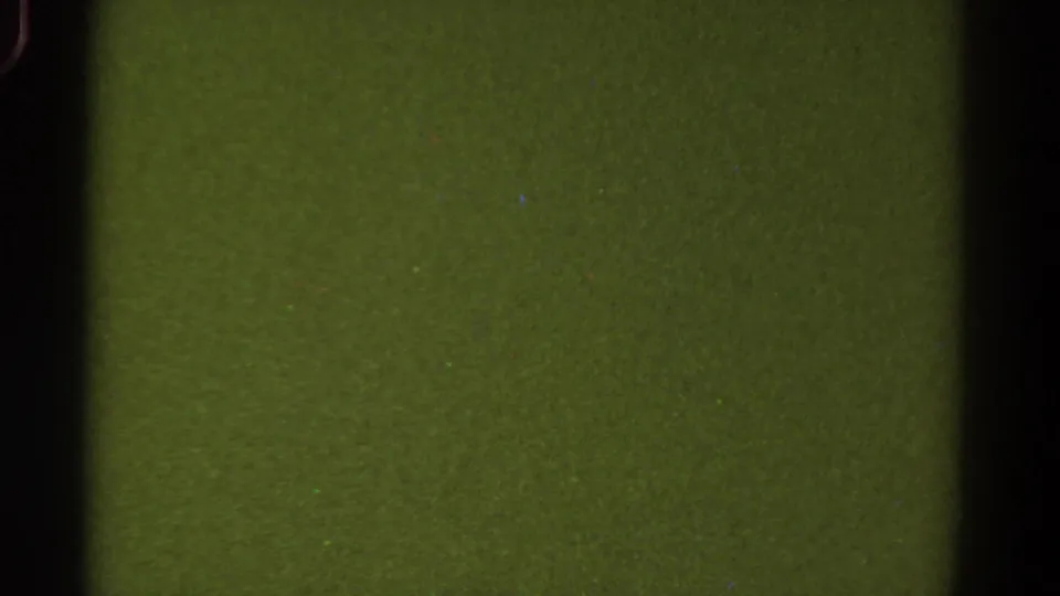 1967 Colorado 8mm frame with a uniform green surface, black side border, soft gate edge, and analog grain.