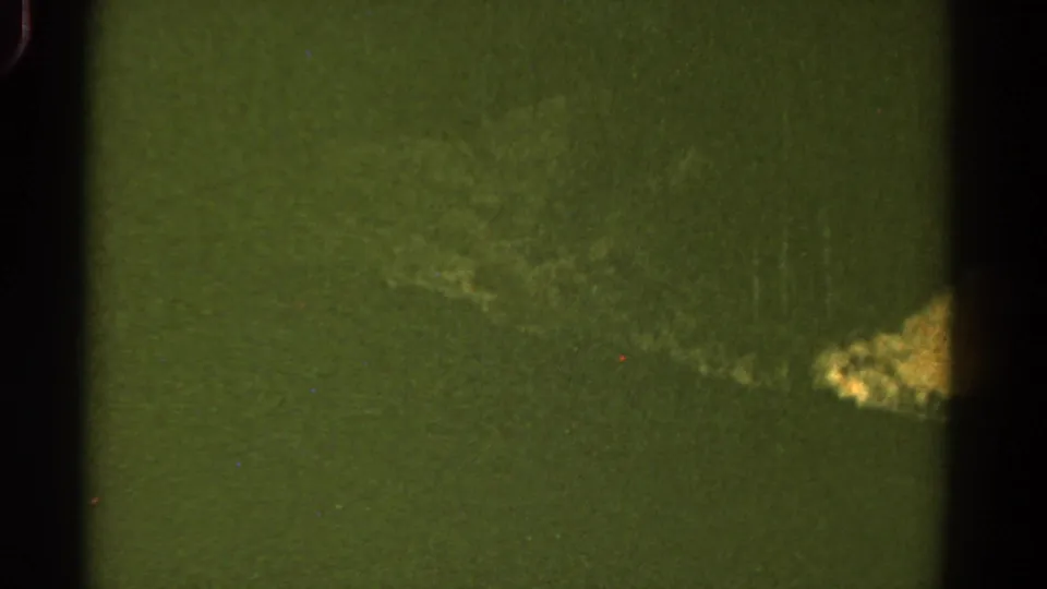 1967 Colorado 8mm frame dominated by green-tinted ground and a small pale rocky patch near the edge.