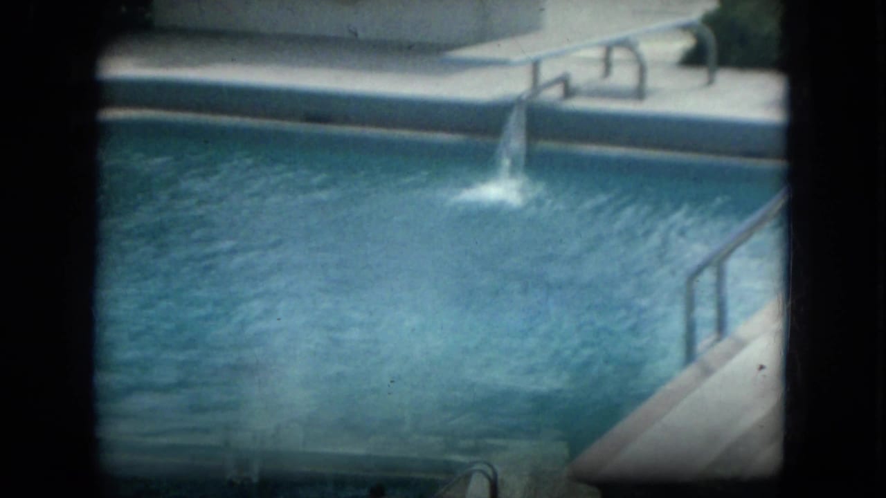 Pool water, deck, handrails, and a person near the far edge.