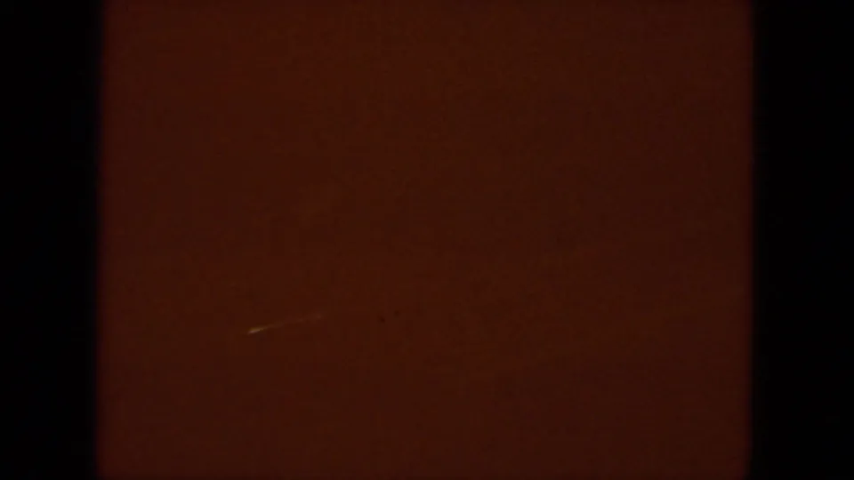End of the 1967 8mm clip showing a dark reddish-brown film section with minimal visible detail and a small light mark.