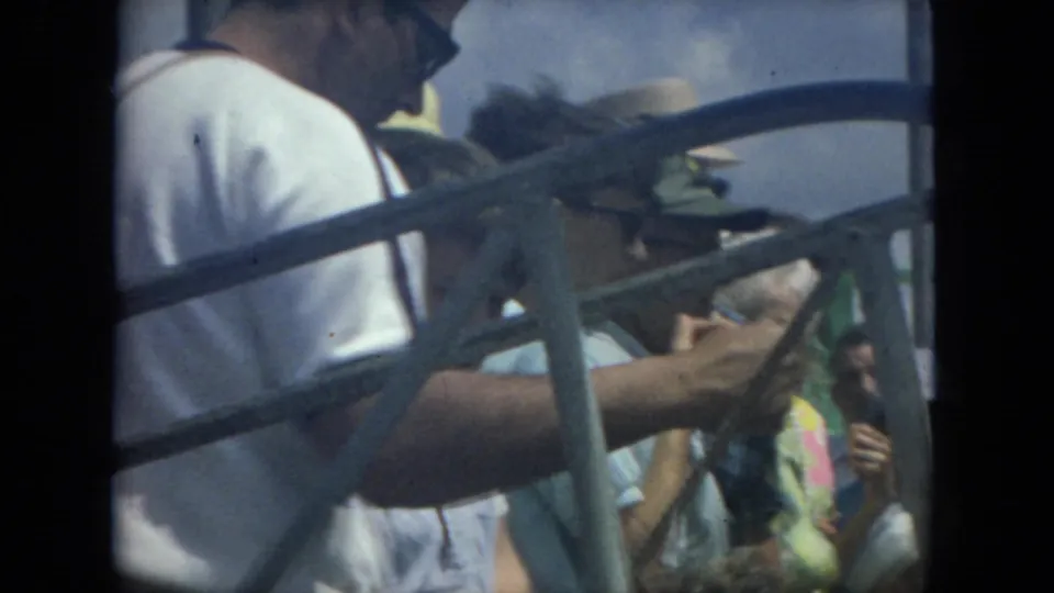 1967 Florida boat passengers viewed through railings, with a man in a white shirt and a woman in patterned clothing partly visible.