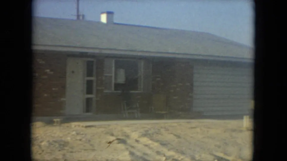 1967 Florida 8mm frame showing the house front, porch chairs, window, and light siding along the right section.