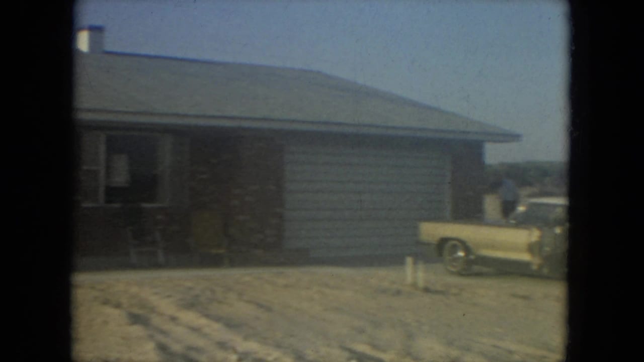 Gold car and brick house partly visible as the camera pans across the driveway.