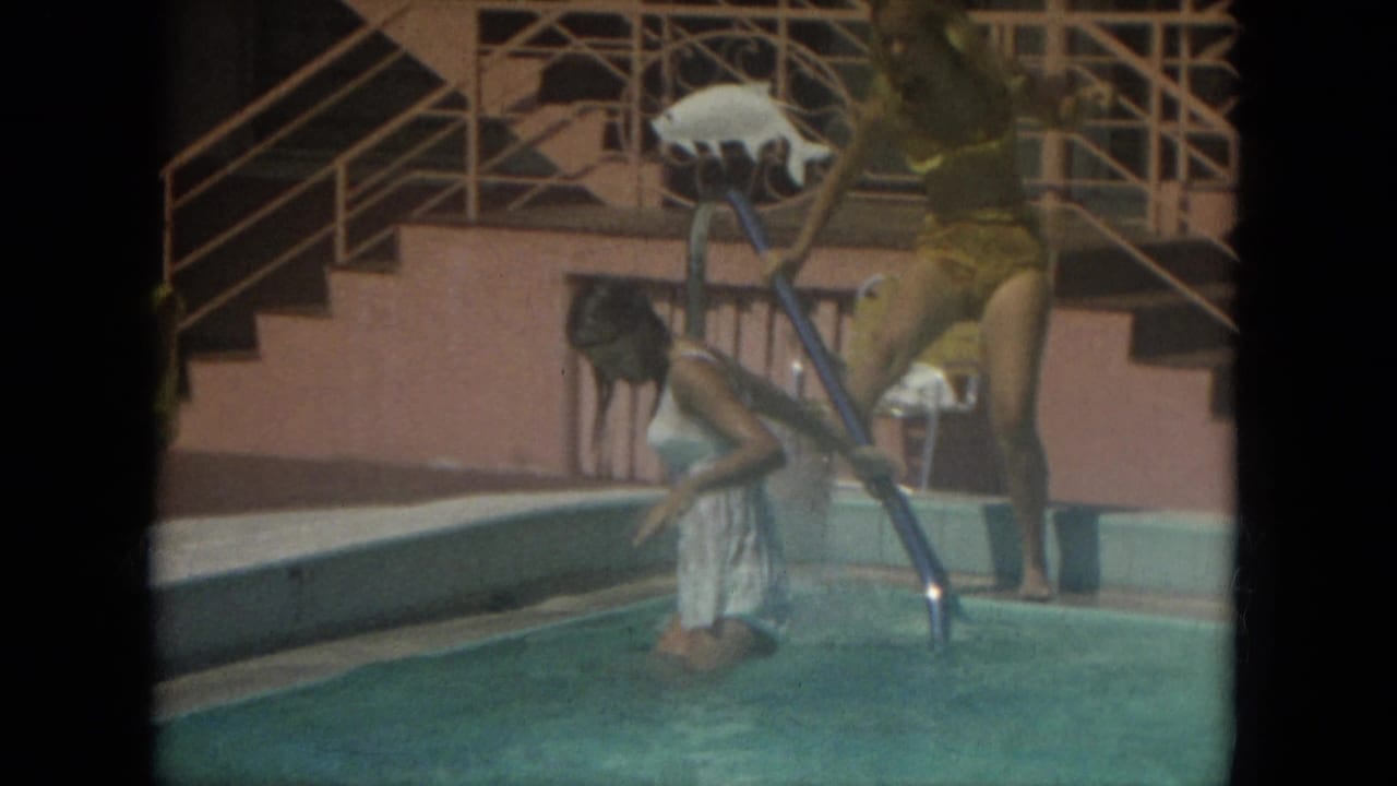 A woman in a yellow swimsuit holds a pool skimmer as another woman in white kneels in the Florida pool in 1967.