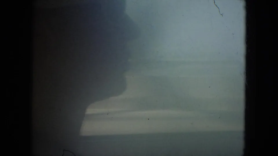 1967 Florida 8mm frame showing a dark passenger or driver profile against a hazy view through the vehicle window.