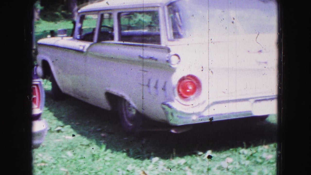 White 1960s station wagon seen from the rear side in 1967 Galena, Illinois home-movie footage.