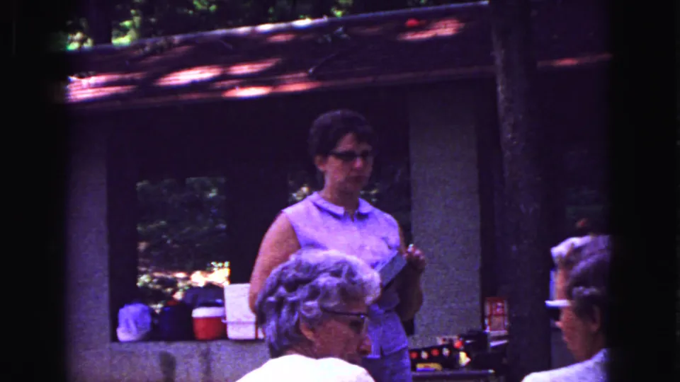 Galena, Illinois home-movie frame with seated patrons and a woman at a rustic restaurant counter, filmed in 1967.