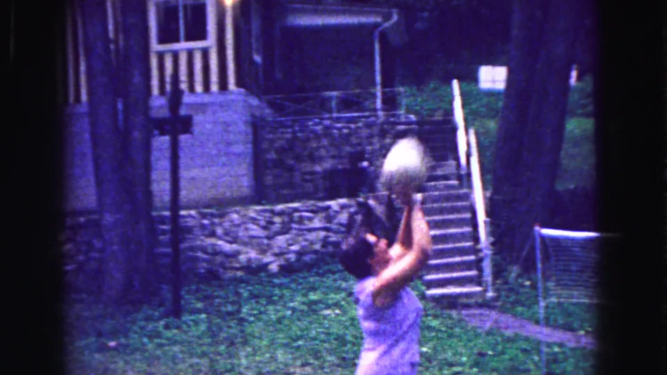 The backyard volleyball game continues as a woman prepares to set the ball near stone steps and a portable net in Galena, Illinois.