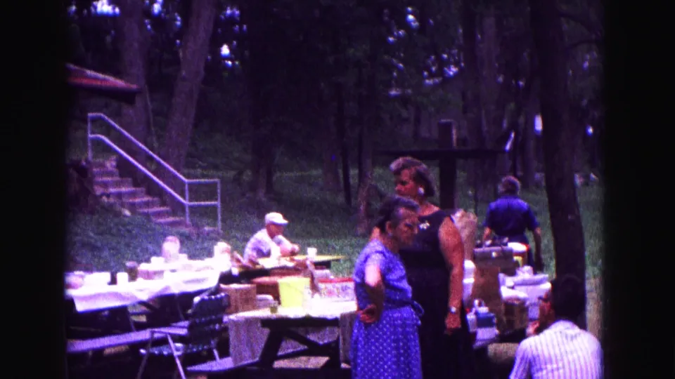 A wider 8mm view shows adults around covered picnic tables, with park steps, railings, trees, and chairs visible in Galena.