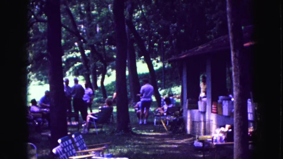 A wider 1967 Galena picnic view shows adults among trees, folding chairs, a grassy clearing, and a small shelter at frame right.