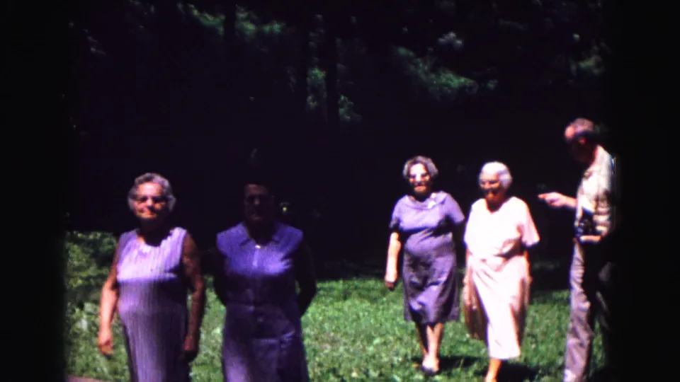 The final frame shows the women walking through the Galena yard, with a man at right gesturing as the group passes through shade.