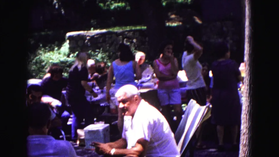 A wooded 1967 Galena picnic scene shows adults socializing around tables, coolers, and folding chairs in home-movie footage.