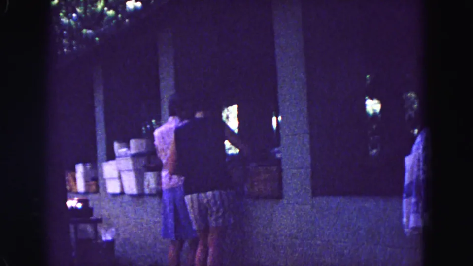 Women appear to sort or handle items at a shaded counter in Galena, Illinois, filmed on 8mm in 1967.