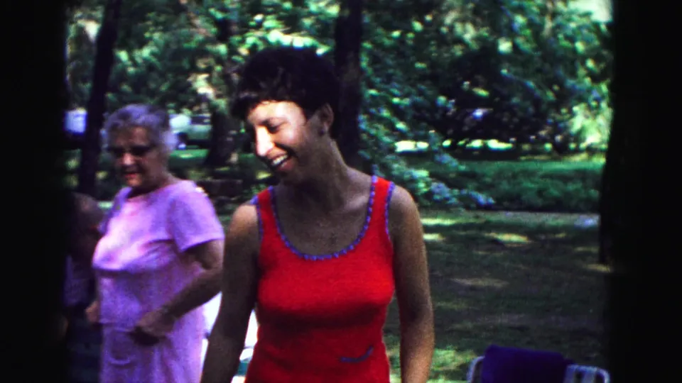 1967 Galena frame with a smiling woman in red and an older woman in lavender at a shaded family park gathering.