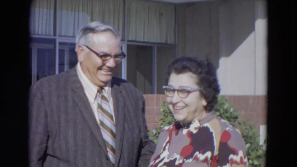 The couple smiles at one another outside the Lincoln building, creating an affectionate moment in the 1967 8mm footage.