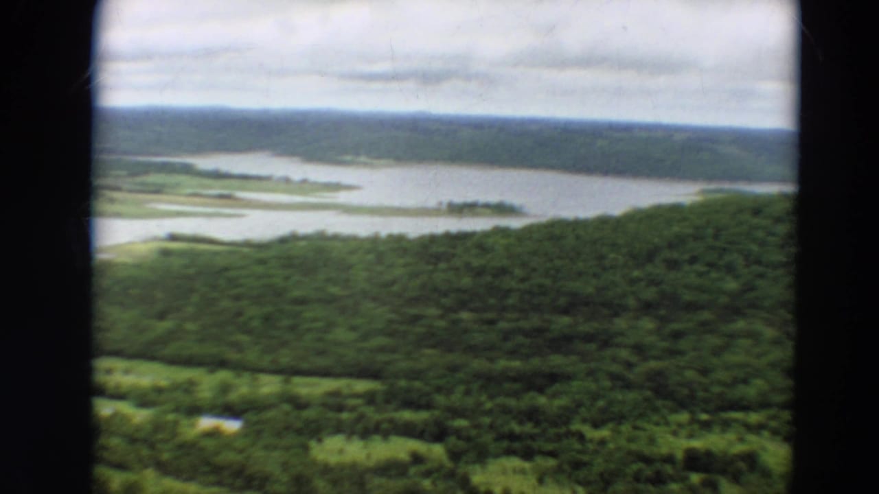 Aerial view of wooded terrain and branching water with film borders visible.