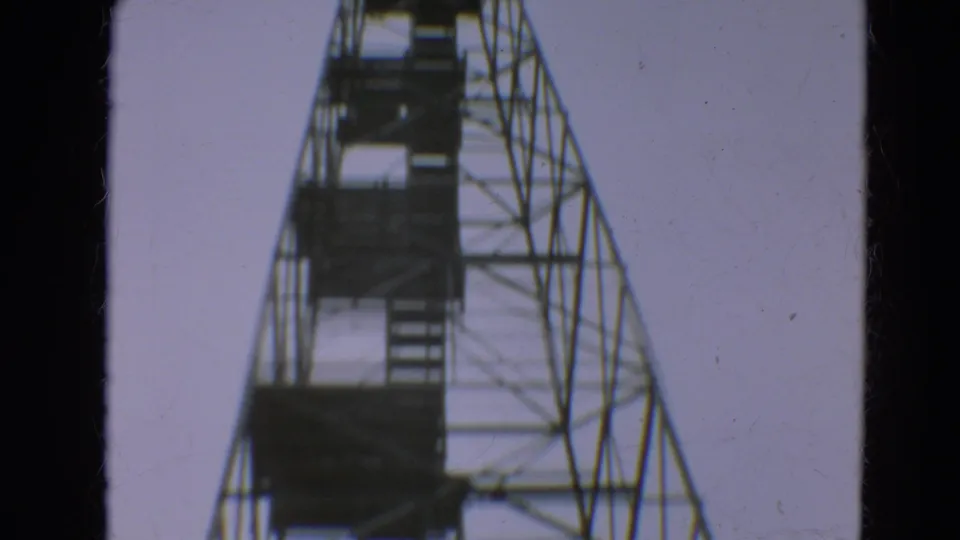 1967 Minnesota 8mm frame looking up the height of a steel observation tower with stairs and platforms.