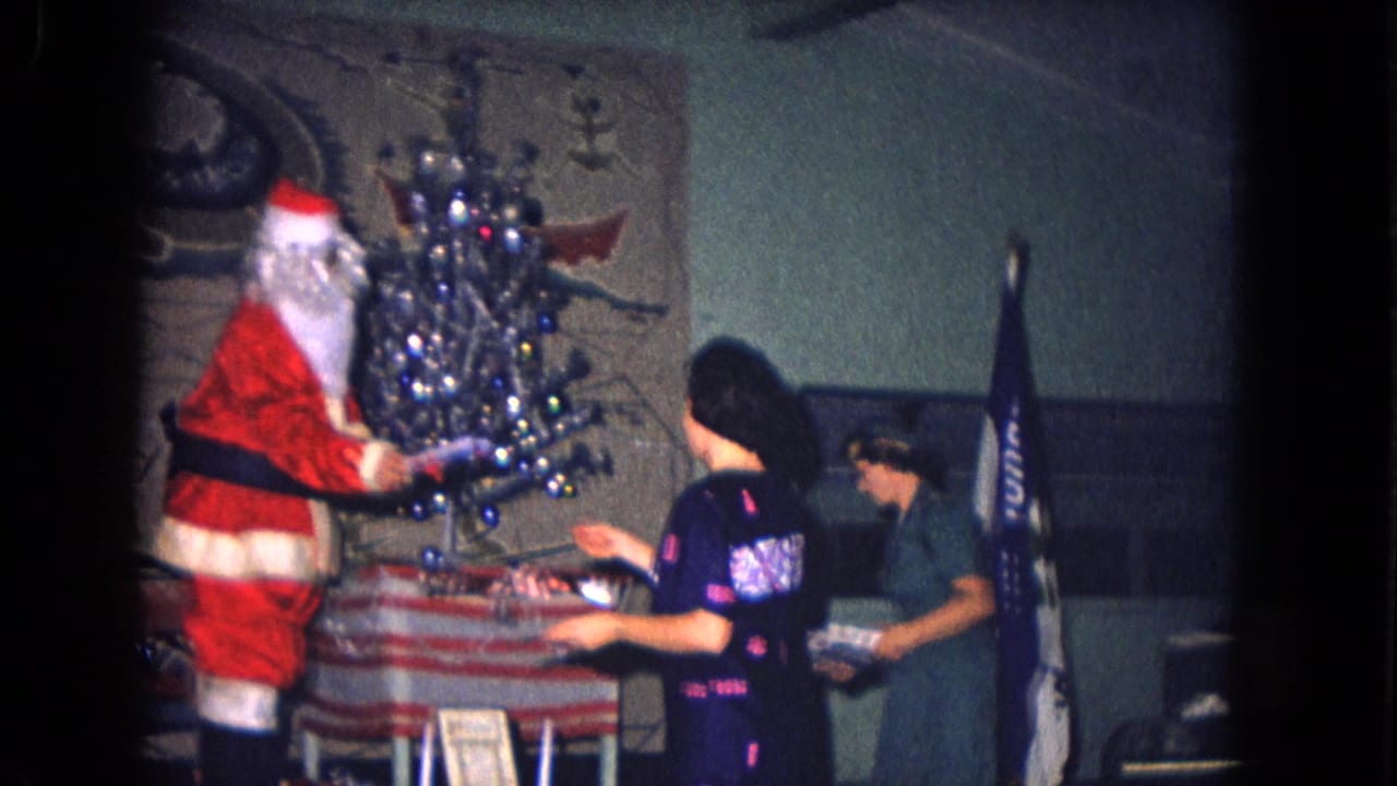 Santa Claus appears beside a small decorated Christmas tree at a 1967 New Mexico military holiday gathering.