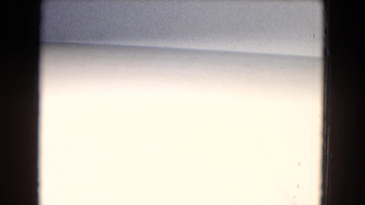 Overexposed pale film frame with dark vertical borders and little visible subject detail.