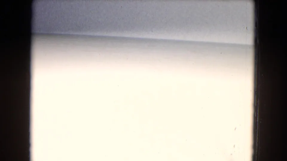A washed-out 8mm frame with dark film edges and minimal visible detail, likely part of the same 1967 home-movie scan.
