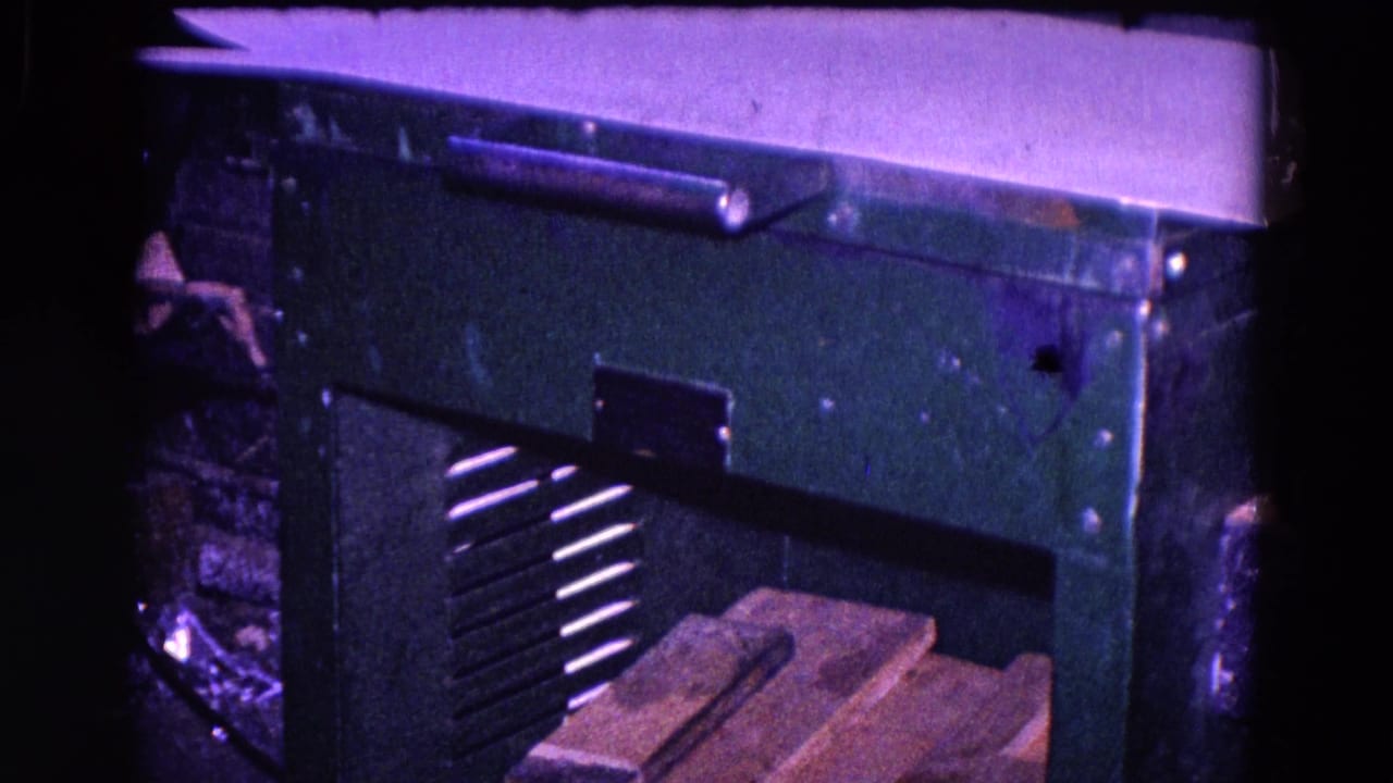 Green industrial machine with vent slats and wooden boards below.