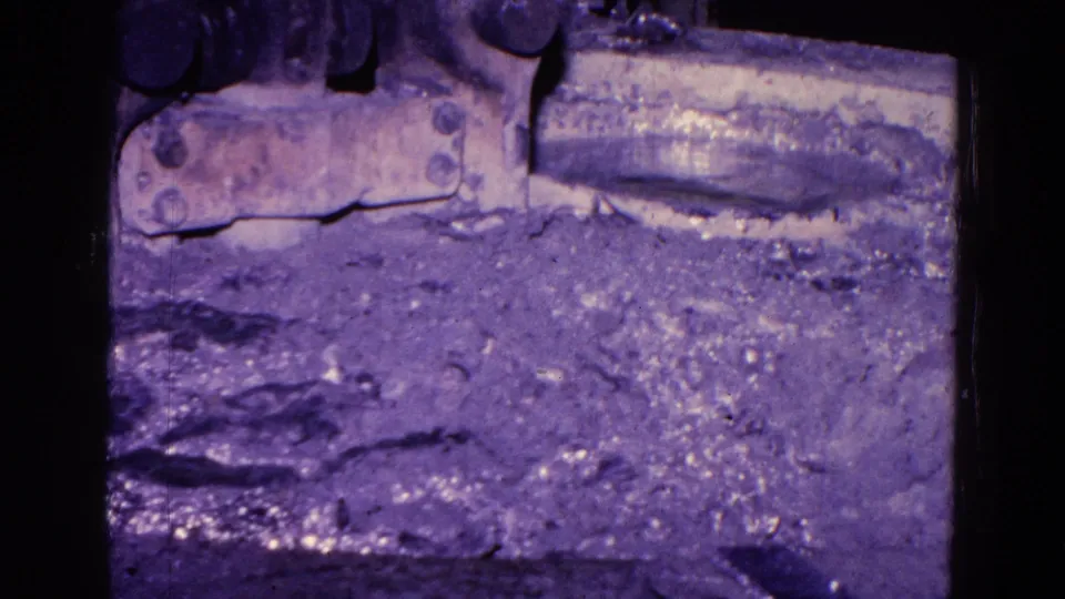 Rough shop floor and the lower edge of the machine appear in the final frame of the Trenton industrial footage.