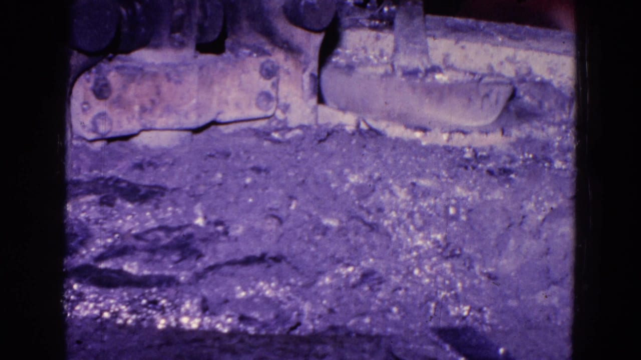 Molten or bright material appears near the top of a rough industrial surface.