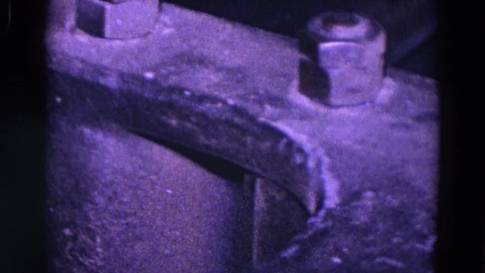 1967 Trenton 8mm frame showing a raised bolt, curved riveted machine edge, and dark worn metal in a close industrial detail.
